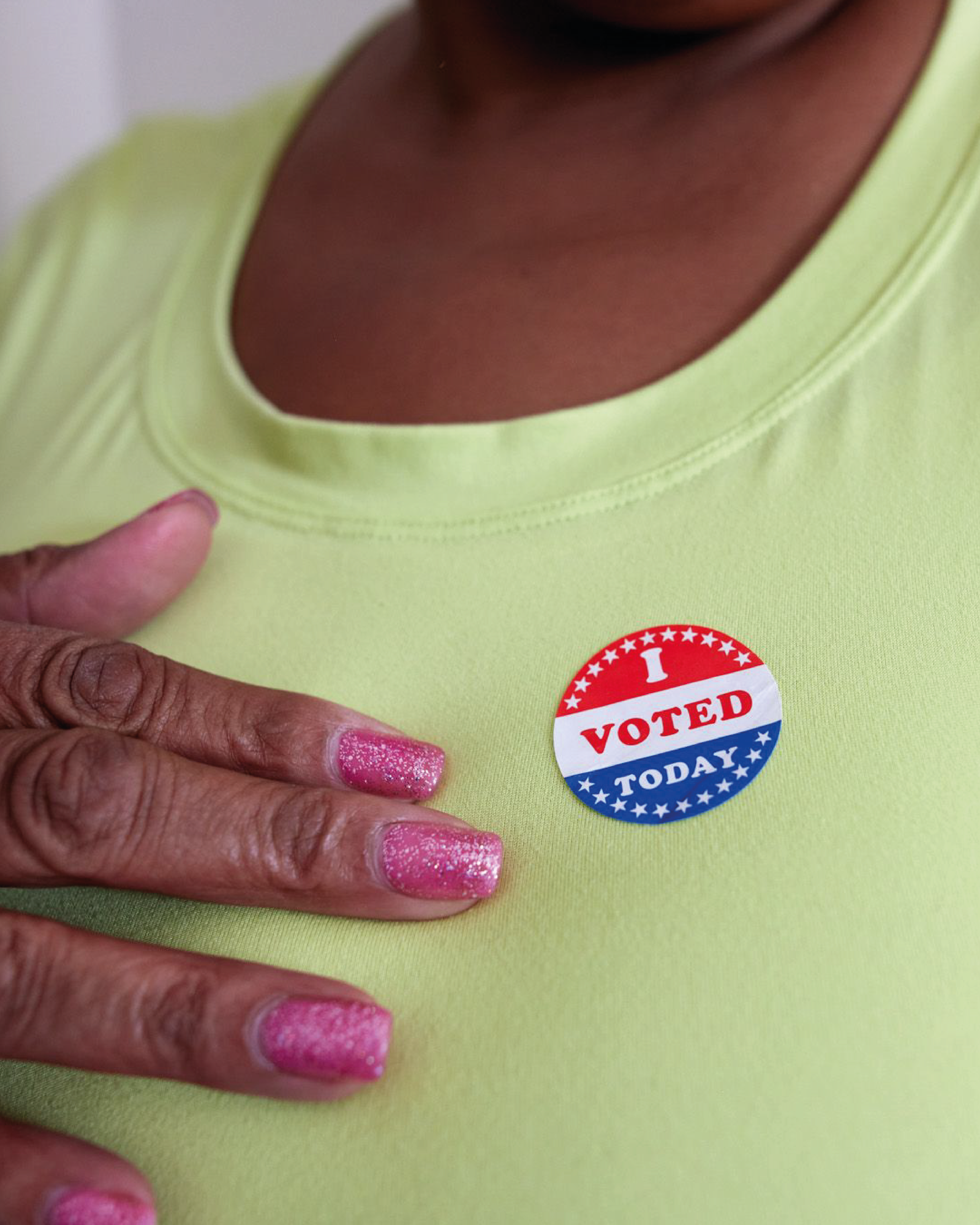 A close-up of an "I voted today" sticker on a lime green t-shirt