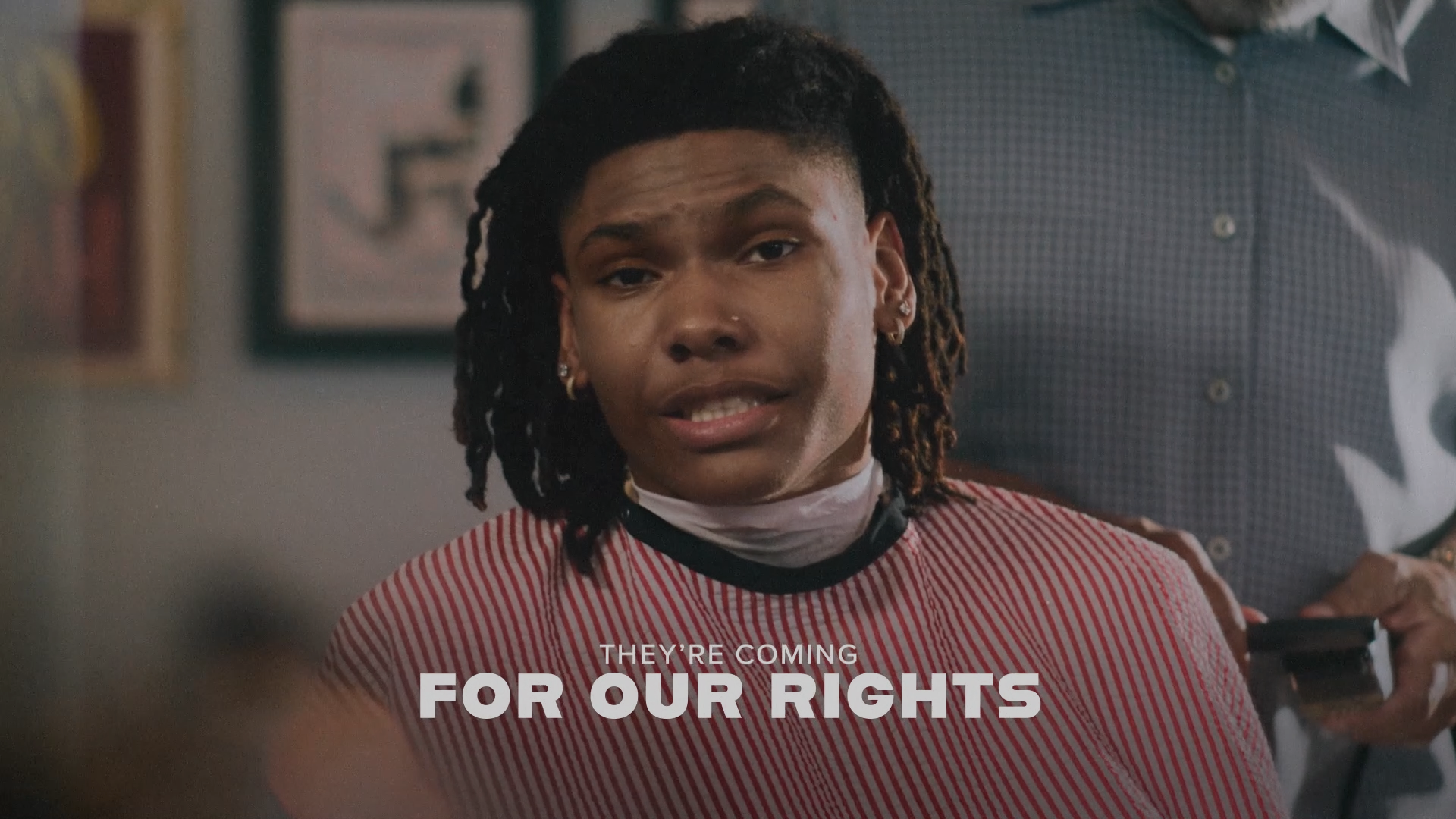 Thumbnail of an ad called "Breaking Through." Image shows a young Black man sitting in a barber's chair looking at camera. Closed caption reads "They're coming for our rights"