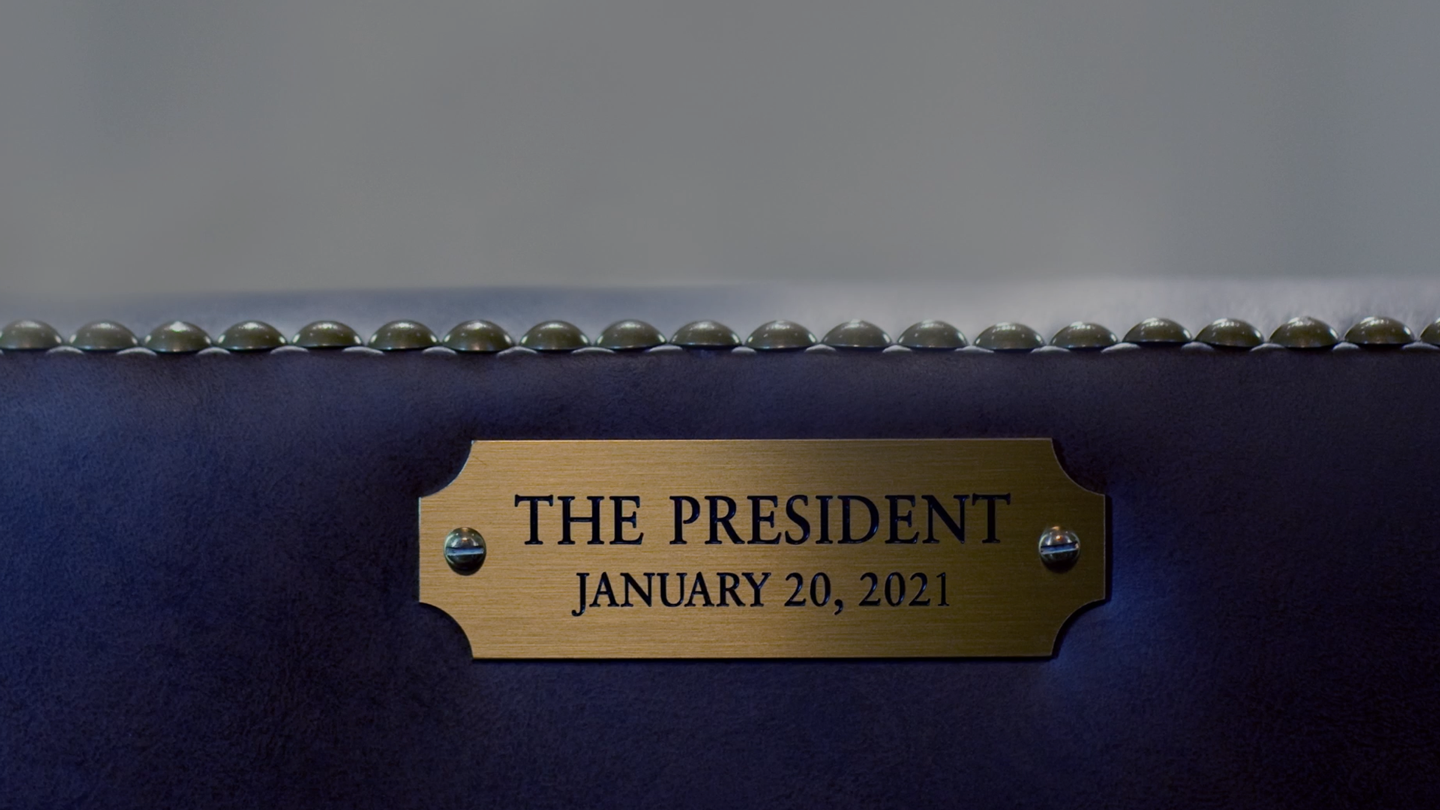 Engraved plate on a chair that reads "The President, January 21, 2021"